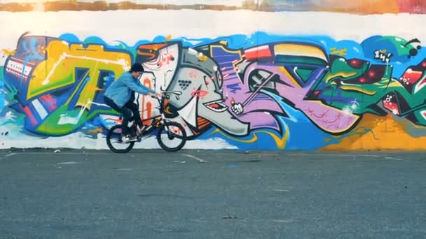 Молодой человек ездит на велосипеде в скейтпарке, замедленная съемка . — стоковое видео