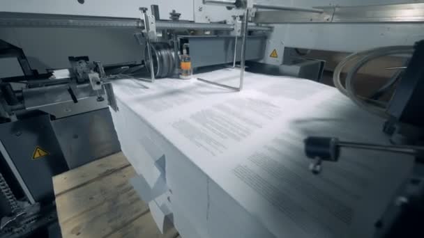 O papel impresso está sendo arrastado para uma máquina industrial — Vídeo de Stock