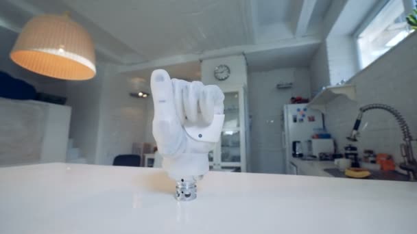 Gebalde vuist van een cybernetische hand staan op een tafel — Stockvideo