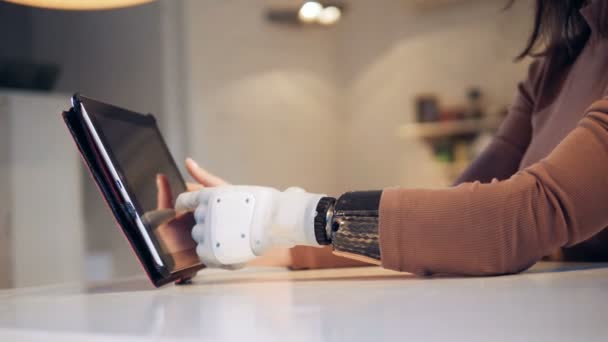La computadora de la tableta está siendo operada por una hembra con un brazo biónico — Vídeo de stock