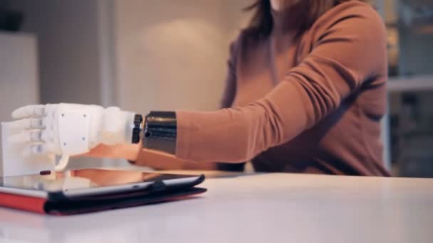 Mujer joven está bebiendo de una taza con su brazo robótico — Vídeos de Stock