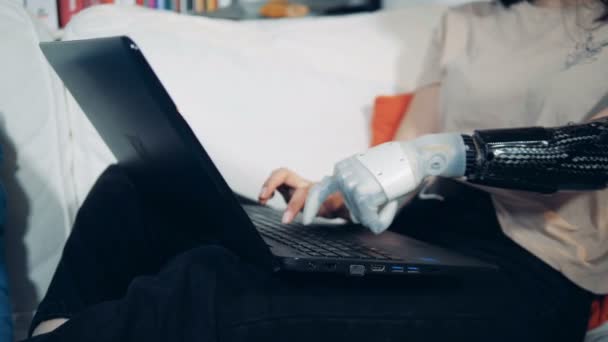 Bir bayan bir sağlıklı ve robot bir el ile bir bilgisayarda yazarak — Stok video