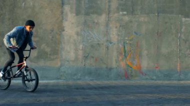 Stunts bir skatepark, yavaş bir bisiklet ile yapan erkek.