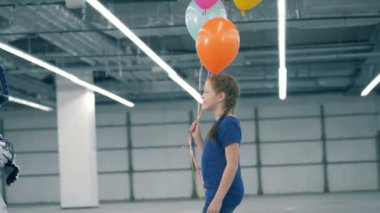 Bir çocuk için beyaz bir robot balonlar verir, yakın çekim.