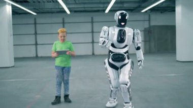 Bir çocuk işleri robot taşırken bir tablet ile yakın çekim.