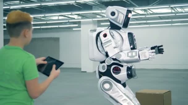 Robotul ia o cutie, controlată de un băiat. Conceptul de viitor . — Videoclip de stoc