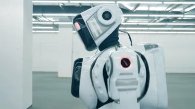 Bir robot, android, cyborg bir odada tek başına yürüyor fütüristik. Fütüristik insansı robot