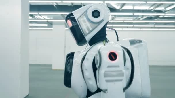 Bir robot, android, cyborg bir odada tek başına yürüyor fütüristik. Fütüristik insansı robot — Stok video