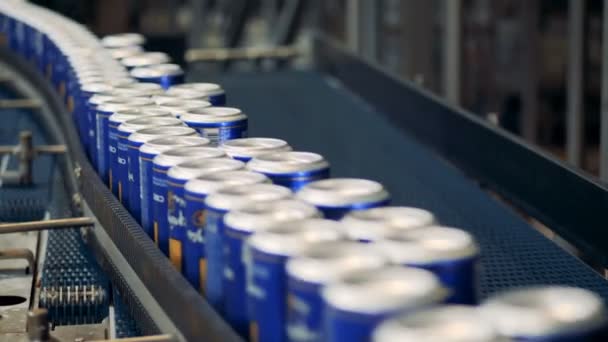 Muitas latas com cerveja em um transportador de fábrica, de perto . — Vídeo de Stock
