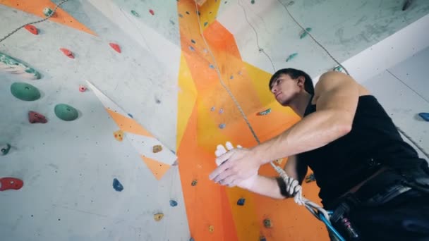 Un escalador mira una pared, vista de fondo . — Vídeos de Stock