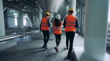 Bir bira fabrikası tesis, arkadan görünüm yürüyüş mühendisleri.
