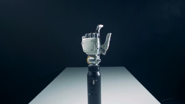 Бионическая рука стоит на столе и движется под наблюдением человека — стоковое видео