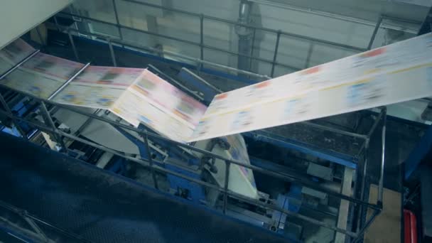 Newspaper sheets moving on a conveyor, close up. — Stock Video