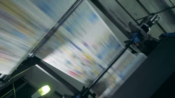 Gekleurde vellen op een transportband bij een drukkerij, close-up. — Stockvideo