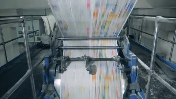 Hojas de periódico rodando en un transportador. 4K — Vídeo de stock