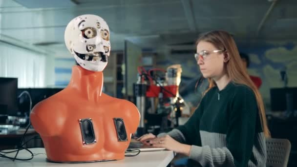 Une femme regarde travailler un robot, de près . — Video