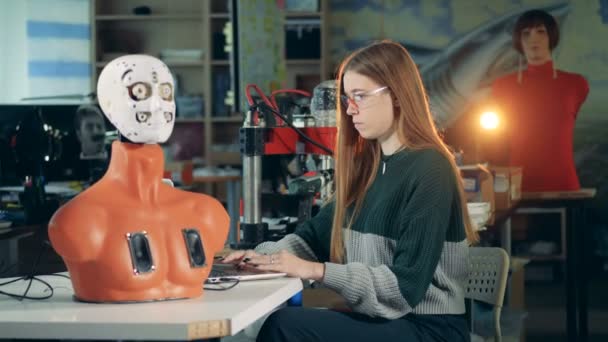 Девушка работает с дроидом в лаборатории, крупным планом . — стоковое видео
