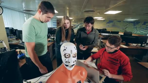 Groupe d'ingénieurs fixer un robot, gros plan . — Video
