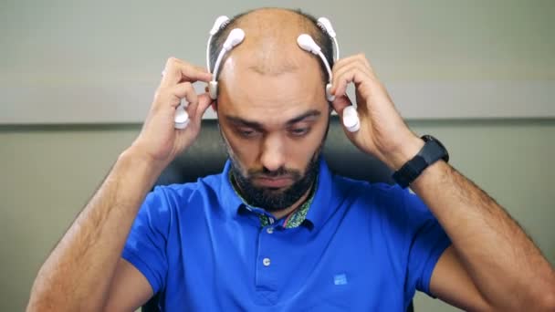 A man puts on sensors on a head, close up. — Stock Video