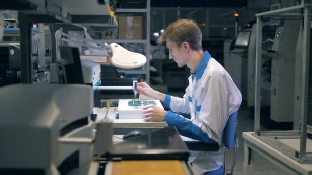 Hombre empleado de la fábrica está haciendo microesquemas — Vídeos de Stock