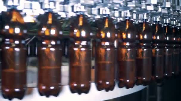 Промисловий механізм транспортування та наповнення пластикових пляшок пивом — стокове відео