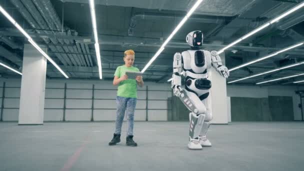 Το παιδί πλοήγηση σε μια συγκινητική droid με τον υπολογιστή του — Αρχείο Βίντεο