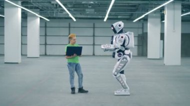 Genç çocuk ve arkanı dön taşımak için bir robot manipüle olduğunu