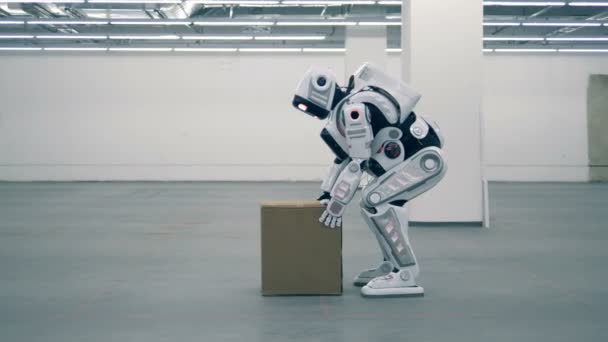 Cyborg lyfter en kartong och bär den — Stockvideo