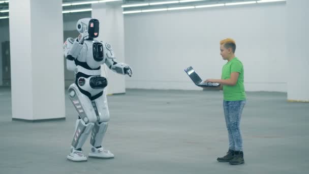 机器人在男孩的操纵下移动它的手和身体 — 图库视频影像
