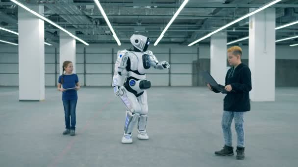 Wesoły cyborg jest w ruchu w obszarze nawigacji z dwójką dzieci — Wideo stockowe