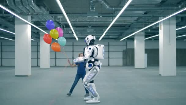 Happy girl with balloons is running around an anthropoid robot — Stock Video