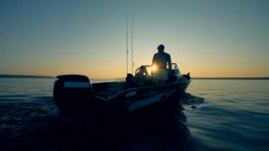 Erkekler bir göl balıkçılık iken bir motorlu tekne sür. 4k