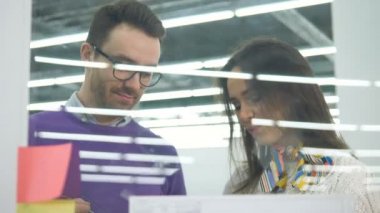 Erkek ve kadın mühendisler plastik bir tablosunu kullanarak ve bir tartışma sahip