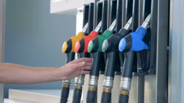 Bir adam bir gaz tabancalar kaldırıyor. Benzin, benzin, yakıt, petrol kavramı.