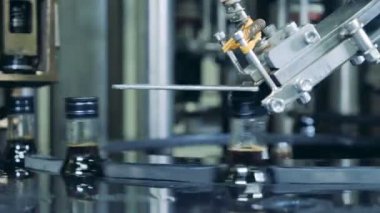 Kapaklar şişeler, alkollü üretim yerleştirerek çalışma makine.