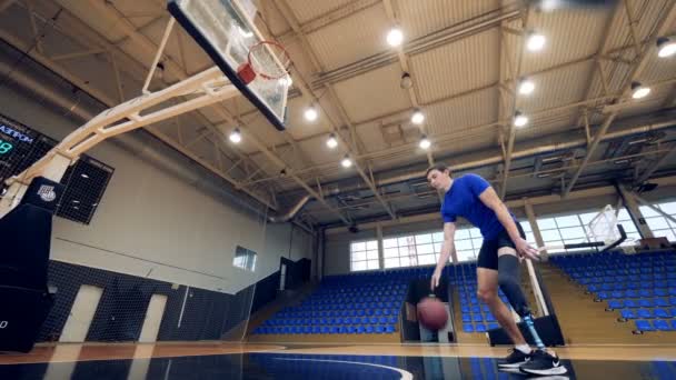 Нижний Новгород, Россия - CIRCA November 2018: A man with a prosthetic leg is playing basketball — стоковое видео