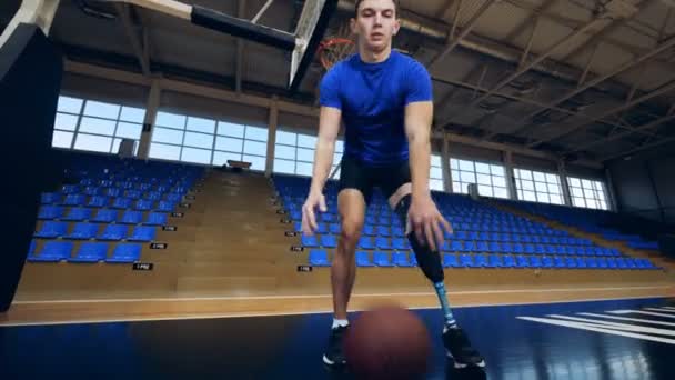 Nižnij Novgorod, Rusko - cca listopadu 2018: Muž s umělou nohou hraje basketbal v prázdné tělocvičny — Stock video