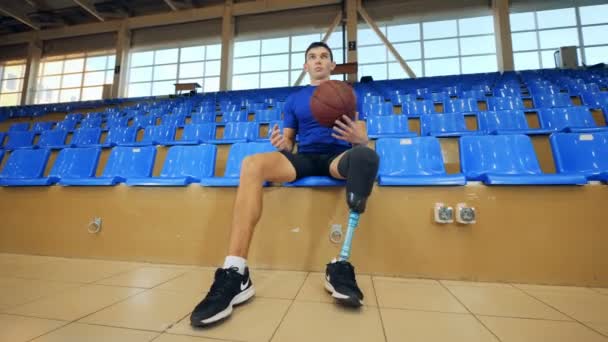 Nizhny Novgorod, Rusia - CIRCA Noviembre 2018: El jugador de baloncesto discapacitado está sentado en el gimnasio vacío — Vídeos de Stock