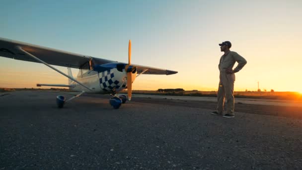 Aviador masculino mira su avión ligero, vista lateral . — Vídeos de Stock