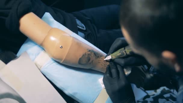 Synthetische hand met een tatoeage op het krijgen van getekend — Stockvideo
