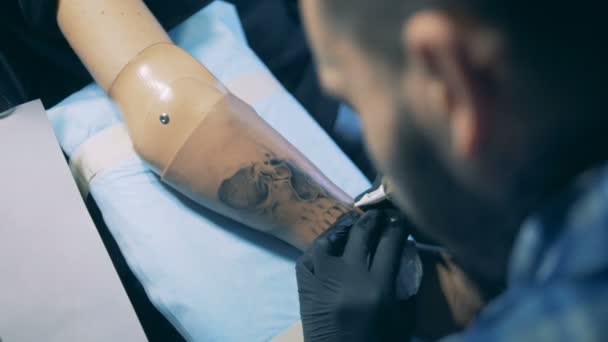 Tatuaje de tinta negra se hace en un brazo protésico masculino — Vídeos de Stock
