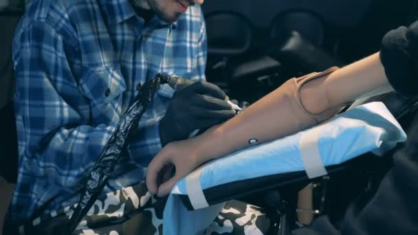 Homem com uma mão protética é uma tatuagem em um estúdio — Vídeo de Stock