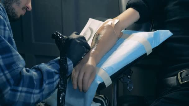 Tatuera en syntetisk hand utförs av den manliga artisten — Stockvideo