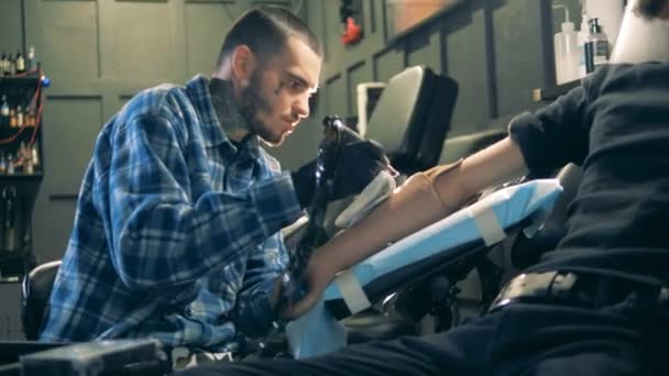 Taller con un artista masculino tatuando un brazo protésico — Vídeos de Stock