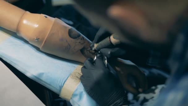 Tattoo toepassing is getting gedaan op een kunstmatige hand — Stockvideo