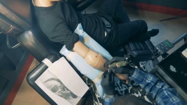 Vista desde arriba del brazo protésico masculino tatuándose — Vídeo de stock