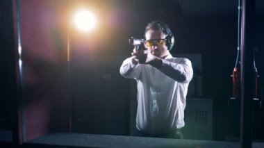 Bir adam bir silah ile çekim bir mesafeden standları, yakın çekim.