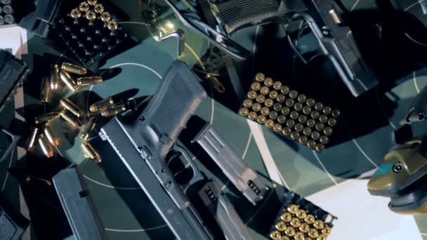 Muitas pistolas com balas em uma mesa, vista superior . — Vídeo de Stock