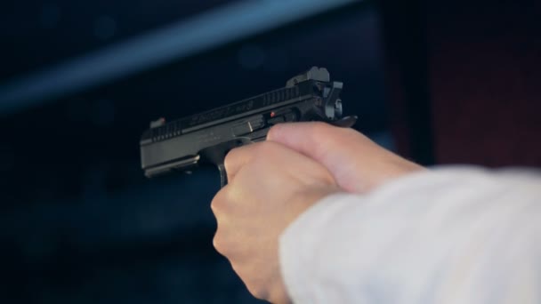 Un uomo spara con una pistola nera, da vicino . — Video Stock