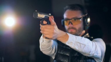 Bir kişi bir tabanca bir mesafeden ateşlendiğinde, yakın çekim.